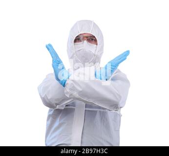 man epidemiologist in coverall disposable anti-epidemic antibacterial isolation suit shows a prohibitory gesture with two hands, isolated on white bac Stock Photo