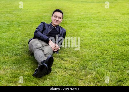 Asian yong man lying on the grass Stock Photo