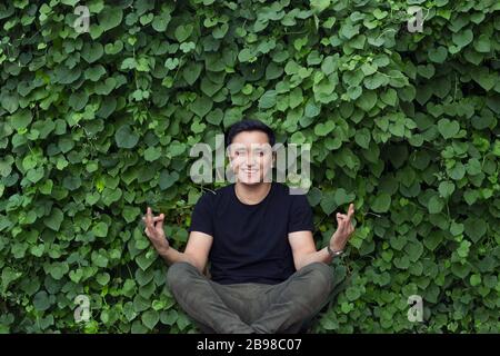 smiling asian young man posing yoga Stock Photo