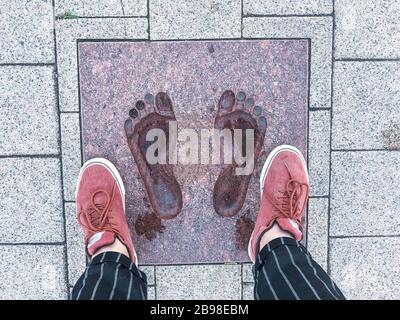 Two decorative footprints on street stone slabs. Studio Photo Stock Photo