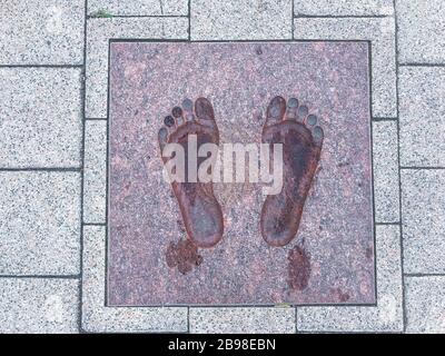 Two decorative footprints on street stone slabs. Studio Photo Stock Photo