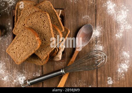 Slices of brown bread with wooden spoon Stock Photo