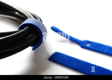 blue velcro cable tie and cable on white Stock Photo