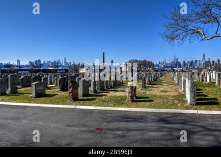 New York City - Feb 23, 2020:  Calvary Cemetery with Manhattan skyline in New York. Calvary Cemetery is a cemetery in Queens, containing more than 3 m Stock Photo