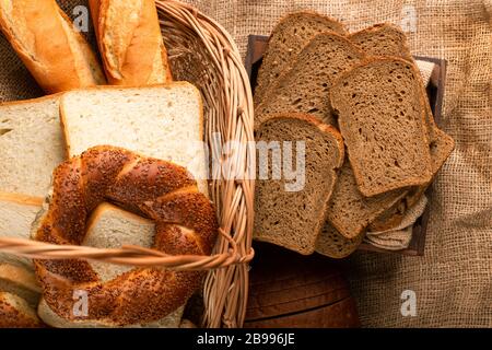 Slices of brown bread in box and bagels with baguette in basket Stock Photo