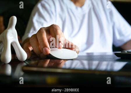 Man working on his computer. Focus on his fingers on the mouse. Stock Photo