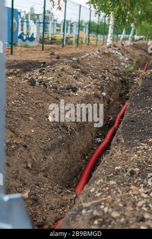 electric cable laying in underground trench. fiber optic cable for fast internet. Stock Photo