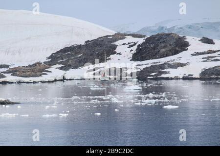A ship at the abandoned British base at Port Lockroy,  now a museum and post office, on the north-western shore of Wiencke Island, Palmer Archipelago, Stock Photo