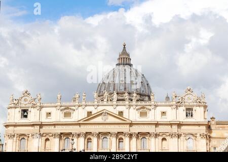 A group of Saint Statues on St. Peter's Basilica with dome and dramatic sky in Vatican City, Rome, Italy Stock Photo