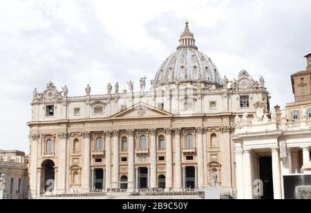 A group of Saint Statues on St. Peter's Basilica with dome and dramatic sky in Vatican City, Rome, Italy Stock Photo
