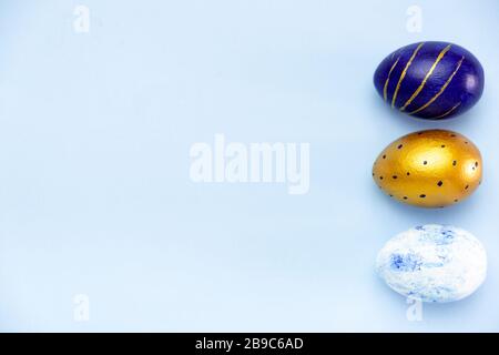 Happy Easter. Frame for text made of easter eggs trendy colored classic blue, white and golden on blue. Minimal style, top view, flatlay, copy space. Stock Photo
