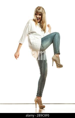 Fashion. Young woman denim pants white sleeve top high heels. Female model  in full length celebrating success with arm raised isolated Stock Photo -  Alamy