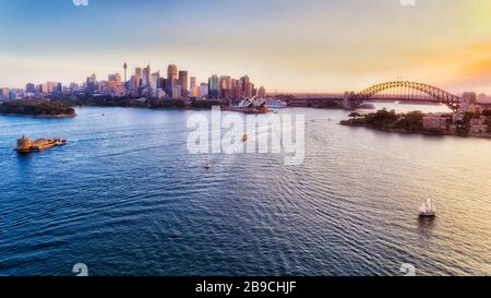 Sydney harbour at sunset around major city landmarks from Fort Denison to the Sydney harbour bridge in elevated aerial view. Stock Photo
