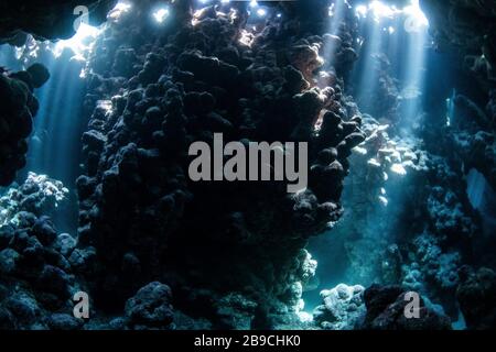 Sunbeams penetrate the cave entrance from above, Red Sea. Stock Photo