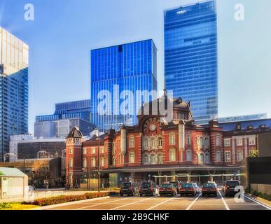 Historic central train station in Tokyo, Japan, in front of modern skyscraper towers on a sunny day. Stock Photo