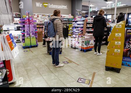 Berlin, Germany. 23rd Mar, 2020. Customers wait for checkout at a supermarket in Berlin, capital of Germany, March 23, 2020. The German government has approved the 'largest aid package' in the country's history to combat the coronavirus, the Ministry of Finance (BMF) announced on Monday. Credit: Binh Truong/Xinhua/Alamy Live News Stock Photo