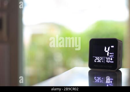 air quality sensor placing on a table indoor. sensor found small amount of air pollution of PM 2.5 the poisonous harmful particulate matter invisible Stock Photo