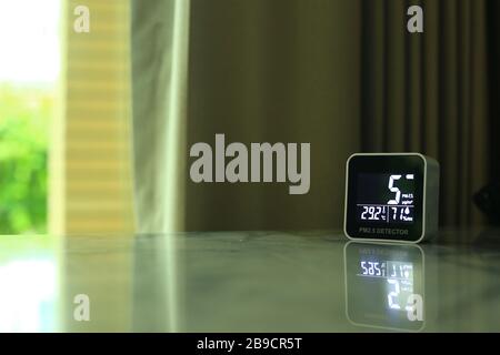 air quality sensor placing on a table indoor. sensor found small amount of air pollution of PM 2.5 the poisonous harmful particulate matter invisible Stock Photo