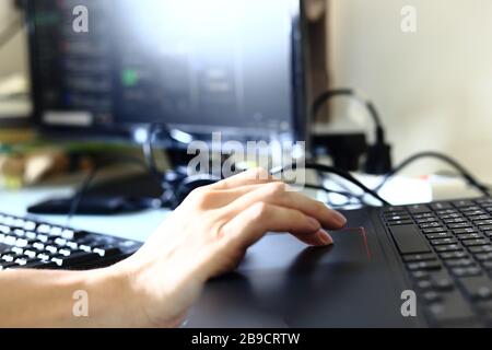work at home concepts. man hand tracking on computer notebook track pad. home office working efficiently with internet connection in virus prone digit Stock Photo