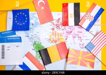 Flags from different countries and boarding pass over world map Stock Photo