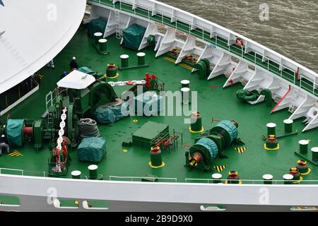 Close up of front deck of ship showing deck furniture on green background and part of the bow Stock Photo