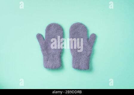 Christmas and New Year cozy holiday composition. Knitted mittens on blue background. Flat lay, top view. Stock Photo