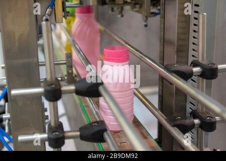Plastic milk bottles on the conveyor on a modern dairy plant. Food industry Stock Photo