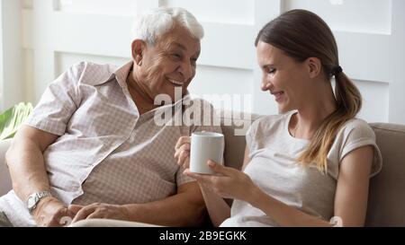 Happy older father and adult daughter chatting, having fun together Stock Photo