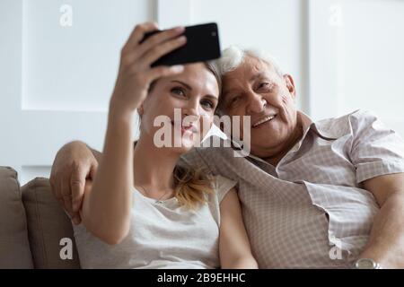 Smiling older father and adult daughter taking selfie on phone Stock Photo