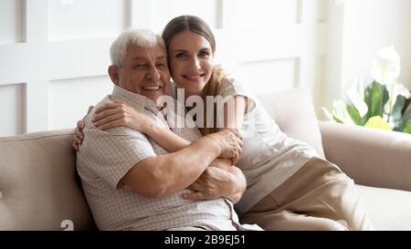Portrait happy older father and adult daughter sitting on couch Stock Photo