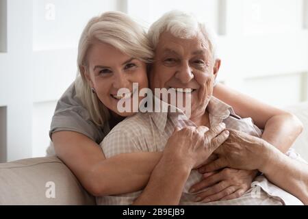 Head shot portrait smiling older wife and husband hugging Stock Photo
