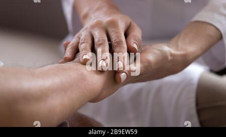 Close up caregiver holding older patient hands, showing support Stock Photo