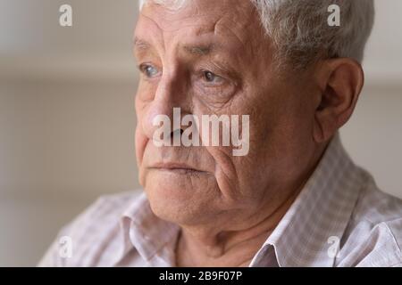 Close up unhappy lonely thoughtful older man looking in distance Stock Photo