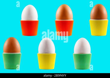 Colorful isolated Easter eggs in cups from the sixties presented with a blue background Stock Photo