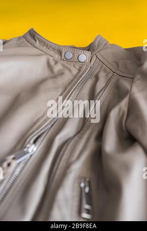 Leather jacket with close up of zipper detail on yellow background. Stock Photo