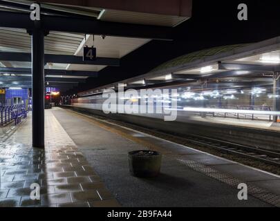 Northern Rail class 158 sprinter train departing from  Blackburn railway station on a dark night with motion blur Stock Photo