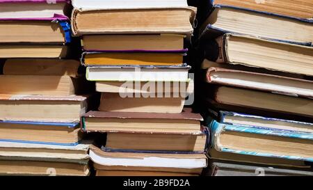 Many used old books in the school library. chaotic layout of stacks of literature, selective focus. A pile of books ends with stacked background. book Stock Photo