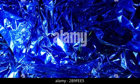 Decoration background from crumpled metal foil, shiny silver surface. Beautiful abstract foil texture as a background for design. Non-ferrous metal. C Stock Photo