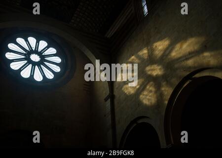 Light from the rose window falls on an interior wall inside the Basilica di San Zeno in Verona, Italy Stock Photo