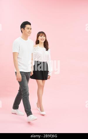 Full length body size photo of couple walking streets of town they have just arrived in while isolated with pastel background
