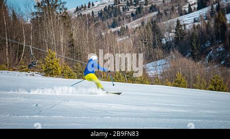 Woman carving on her skis down the slope Stock Photo
