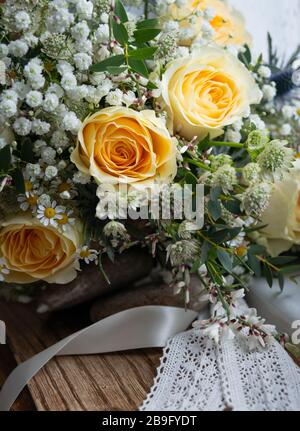 A Wedding Bouquet Of 3 Pale Yellow Roses With Wired Pearls On A White Wedding Cake Stock Photo Alamy