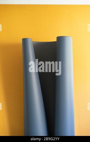 Gray sheet unrolling on yellow background Stock Photo