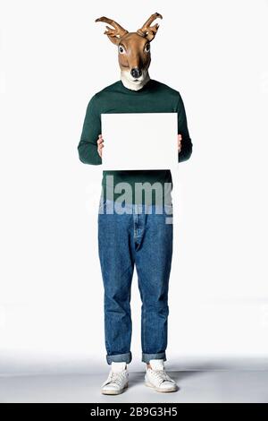 Man in reindeer mask holding blank sign Stock Photo