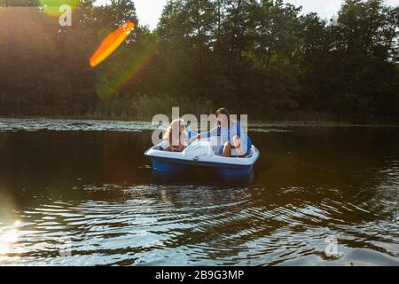 Mother and daughter paddleboating on sunny pond Stock Photo