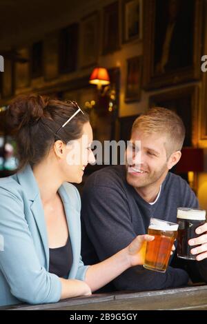 Happy couple drinking beer in pub Stock Photo