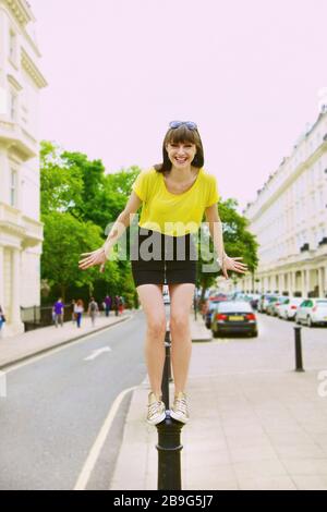 Portrait happy, playful young woman standing on street post Stock Photo