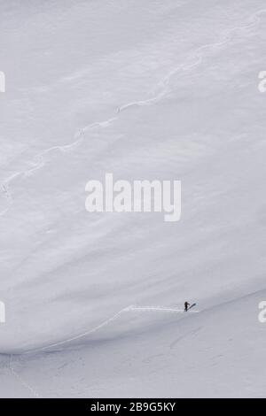 Distant hiker on steep mountain ski slope, Brixen, South Tyrol, Italy Stock Photo