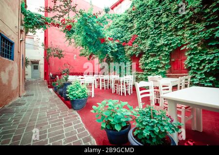 Cafe and restaurants at amazing narrow streets of popular destination on Paros island. Greece. Traditional architecture and colors of mediterranean ci Stock Photo