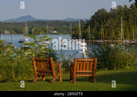 Two wood chairs on overlook view to boats moored in cove in late summer at Lake Champlain Yacht Club Lake Champlain Shelburne, Vt Stock Photo